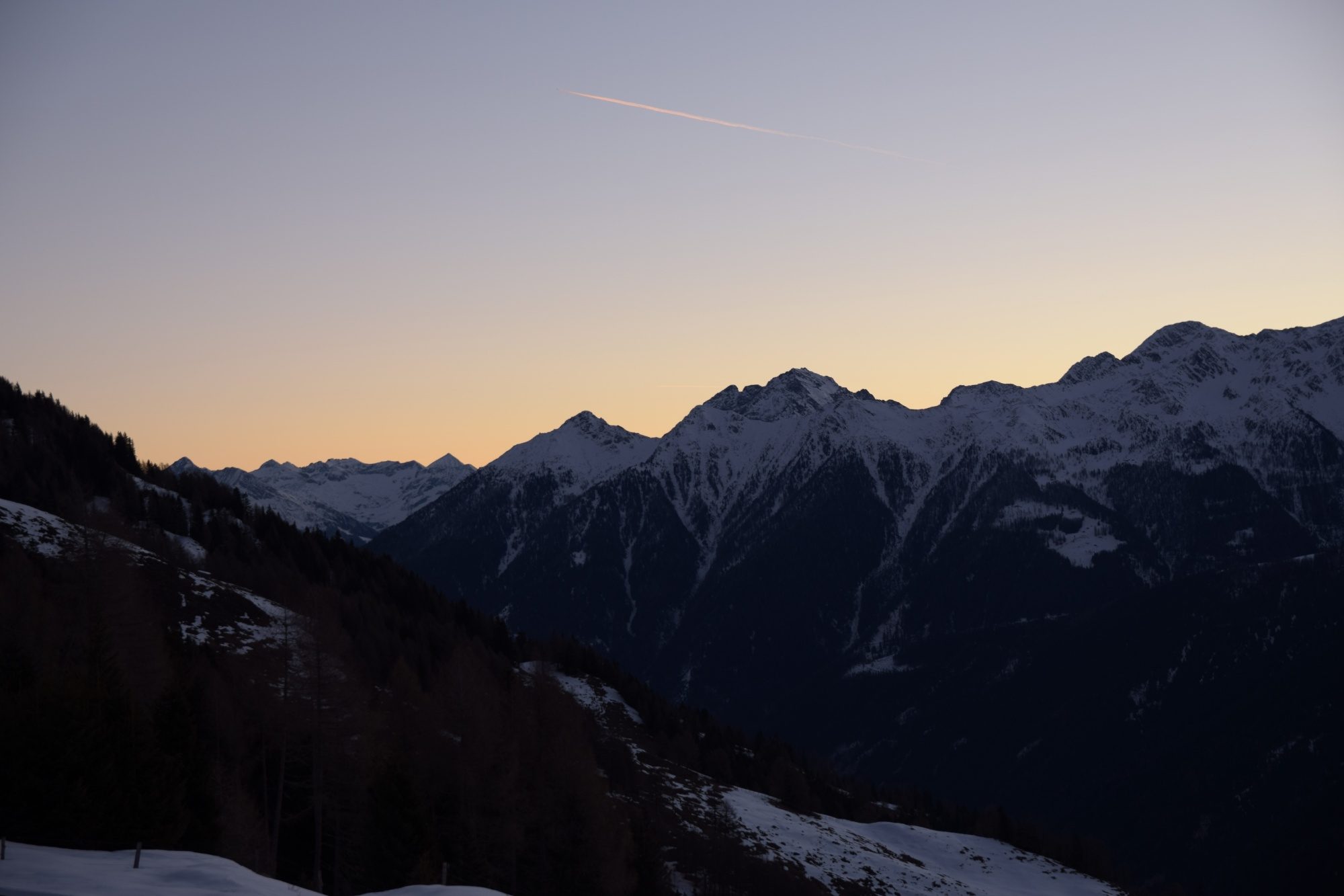 Leichte Morgenröte über Berggipfeln