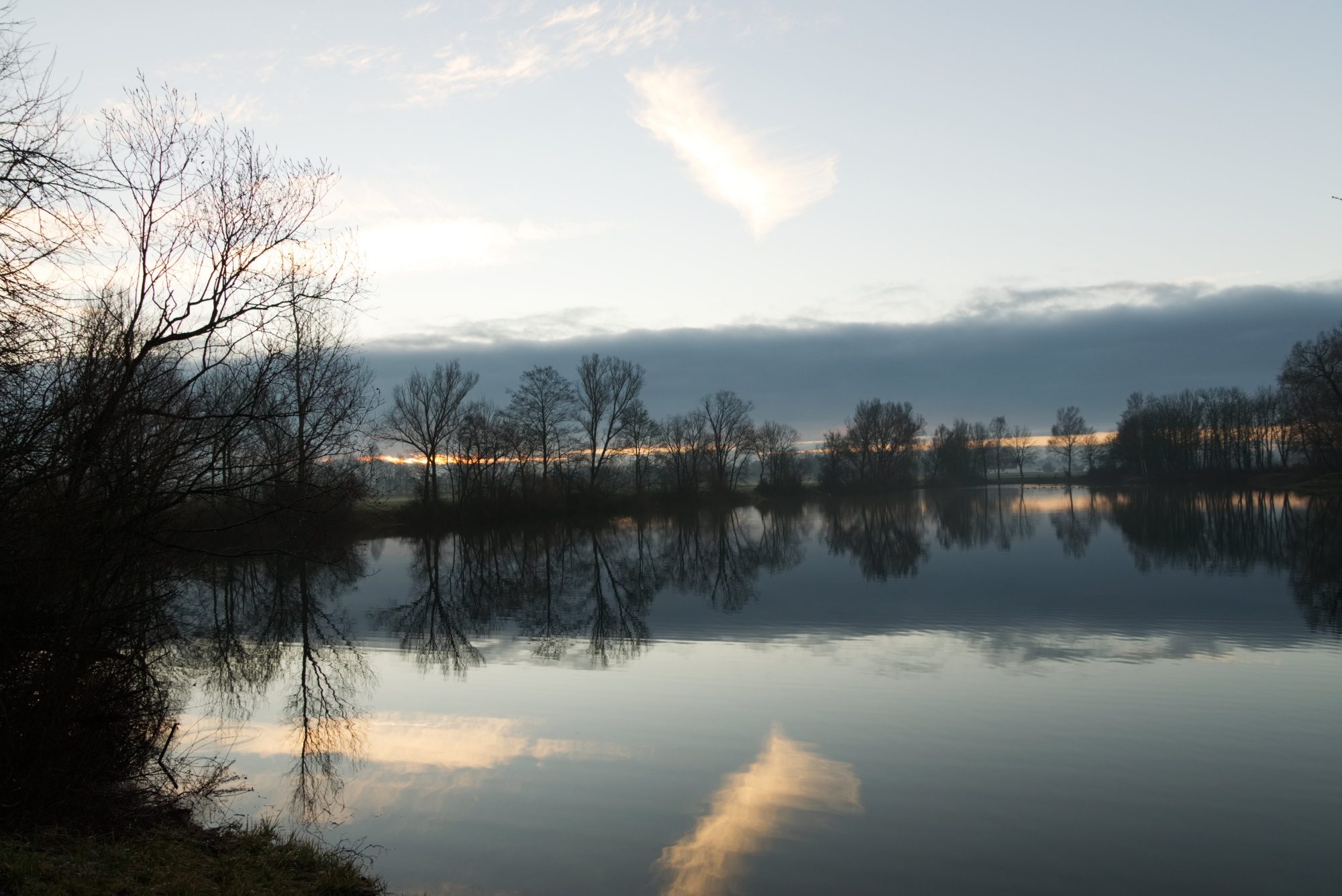 Orangene Wolken spiegeln sich im Weiher